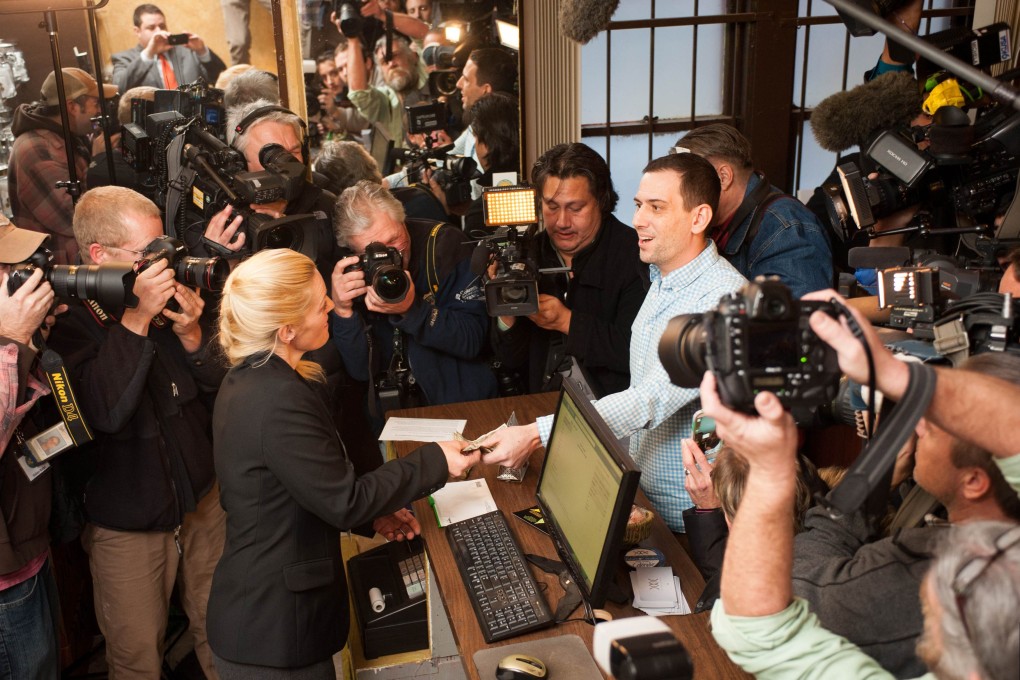Sean Azzariti makes the first legal retail marijuana purchase in Colorado at the 3-D Denver Discrete Dispensary in Denver. Photo: AFP