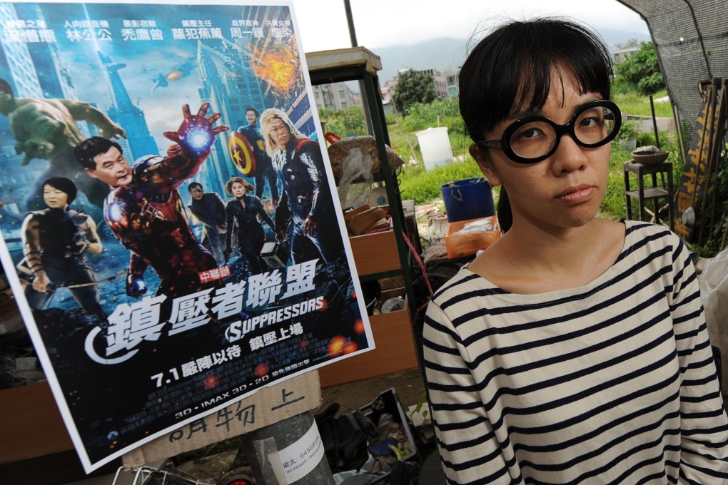 Political activist Ger Choi Tze-kwan stands next to a parody poster of movie The Avengers in May last year.