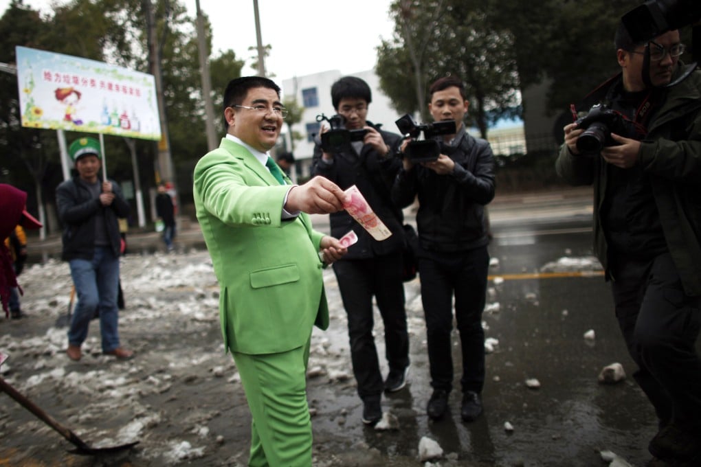 File photo of Chinese multimillionaire Chen Guangbiao giving money away to street cleaners during an event organized by him in Nanjing. Photo: Reuters