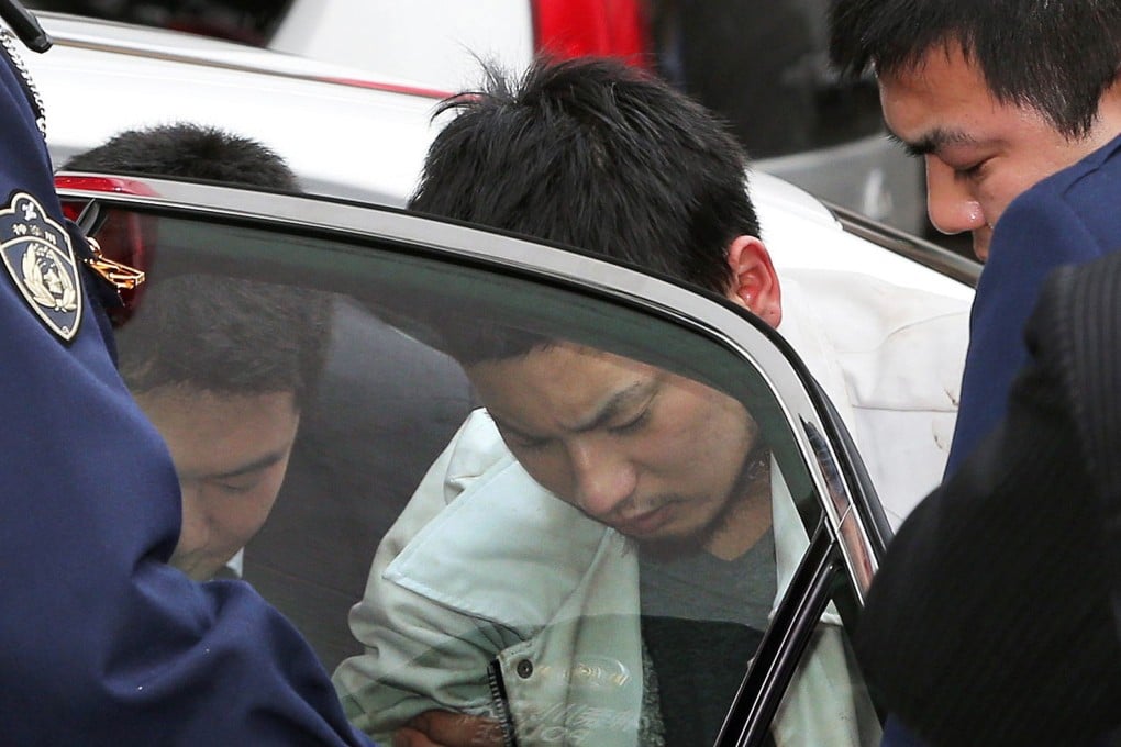 Yuta Sugimoto (centre), who slipped away from his guard while being questioned over a rape case, is captured by police officers. Photo: AFP