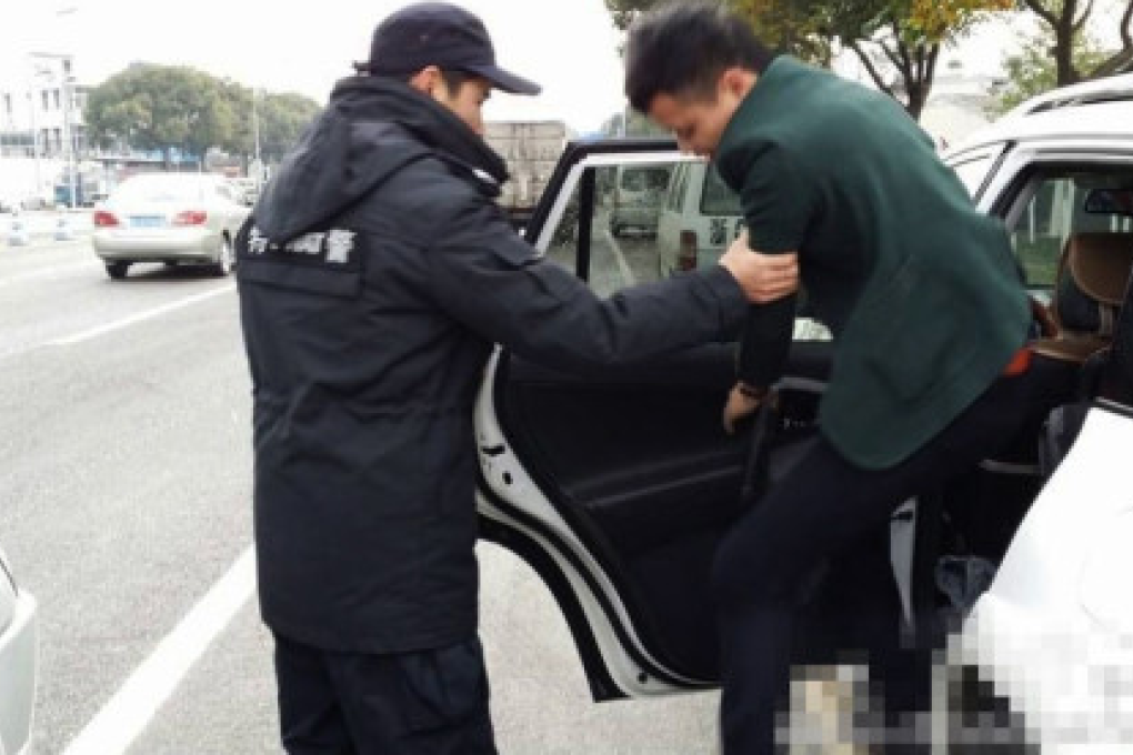 A Sina Weibo photo shows an officer arresting a suspect along a highway on suspicion of killing a tiger. Photo: SCMP Pictures