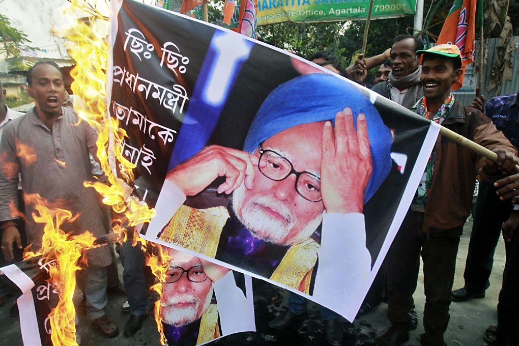 Activists from India's main opposition Bharatiya Janata Party  shout slogans and burn banners with images of India's Prime Minister Manmohan Singh. Photo: Reuters