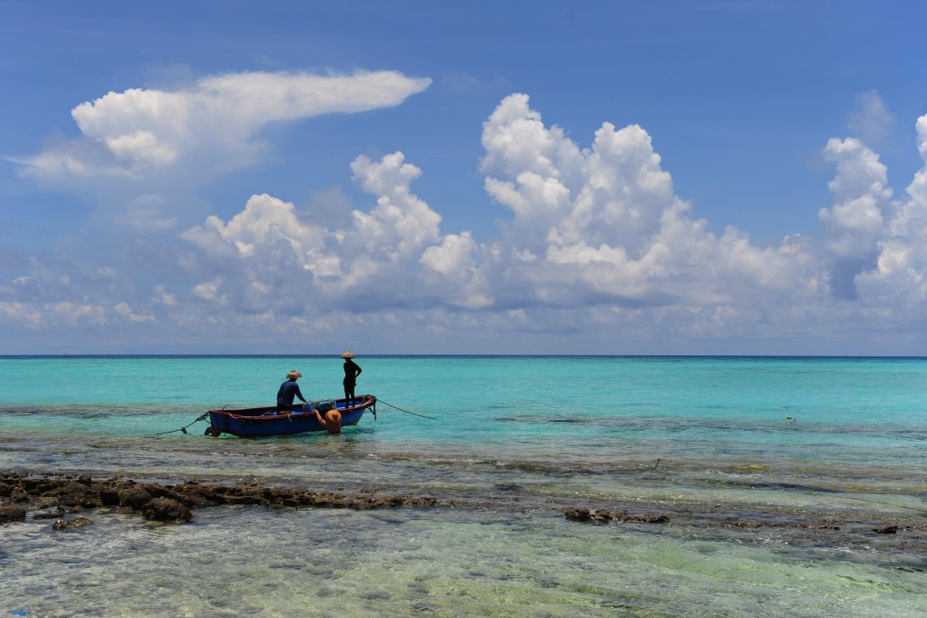File photo taken on May 6, 2012 shows fishermen working on a boat in the surrounding water of the Zhaoshu Island in the South China Sea.  Photo: Xinhua