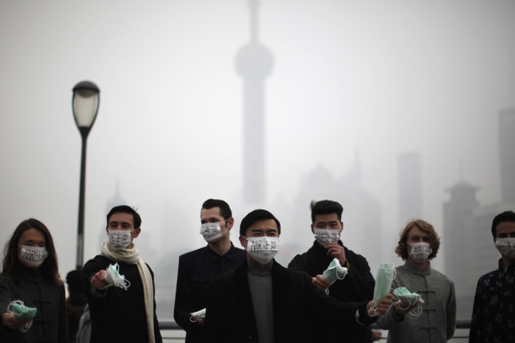 Green activists hand out masks to pedestrians on The Bund yesterday to raise awareness of air pollution in downtown Shanghai. Photo: Reuters