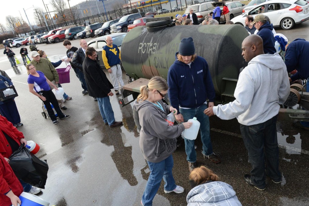 People line up for water after waiting for hours, only to have the water truck run empty in about 20 minutes in Charleston. Photo: AFP