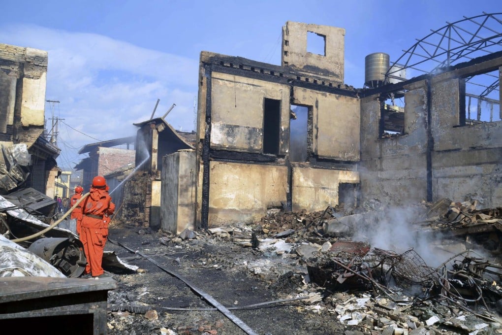 Firefighters douse the last smouldering embers of the fire. Photo: AP