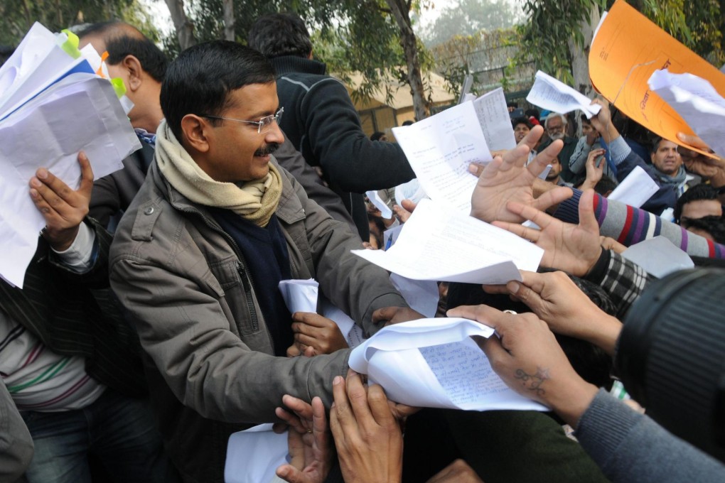 Newly appointed Chief Minister of Delhi Arvind Kejriwal receives letters detailing people's grievances during an AAP rally. Photo: EPA