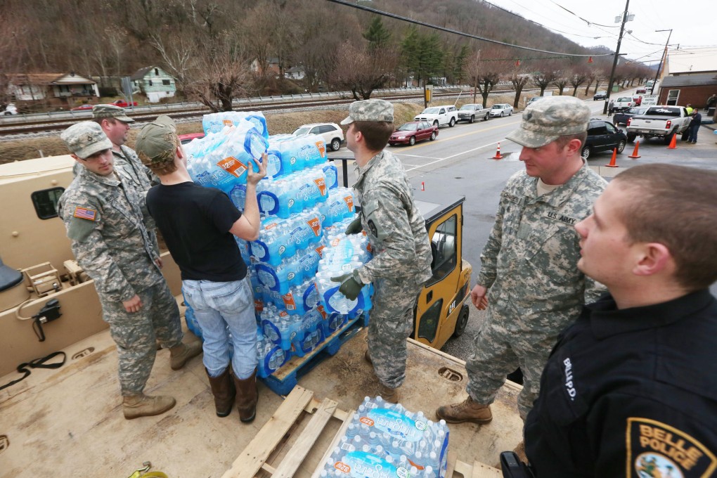 Water is unloaded as city residents queue for supplies. Photo: AP