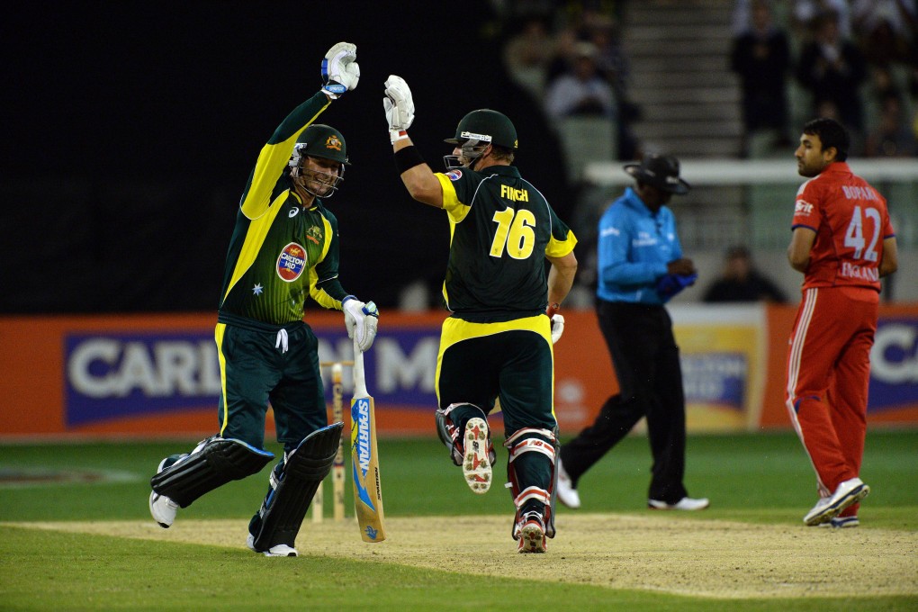 Australia batsman Aaron Finch celebrates scoring a century with teammate Michael Clarke in the first match of the one-day international series between Australia and England. Photo: AFP