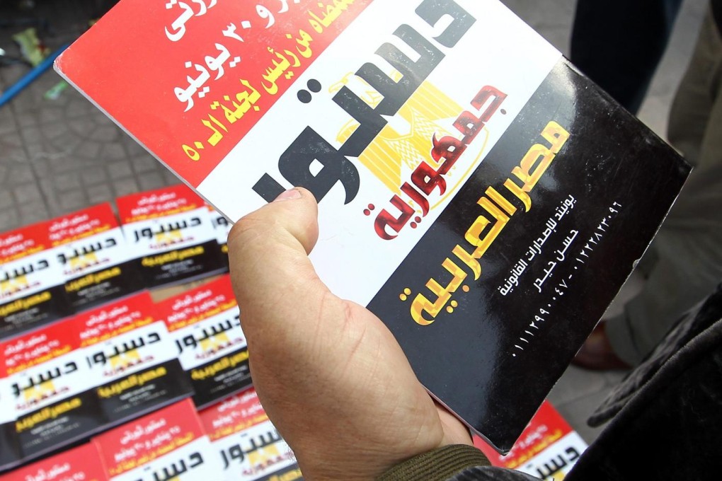 Egyptians look at copies of the new draft constitution. Photo: EPA