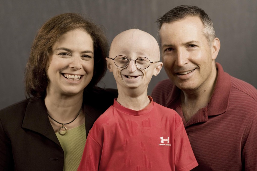 Sam Berns (centre) with his parents, Leslie Gordon and Scott Berns. Photo: MCT