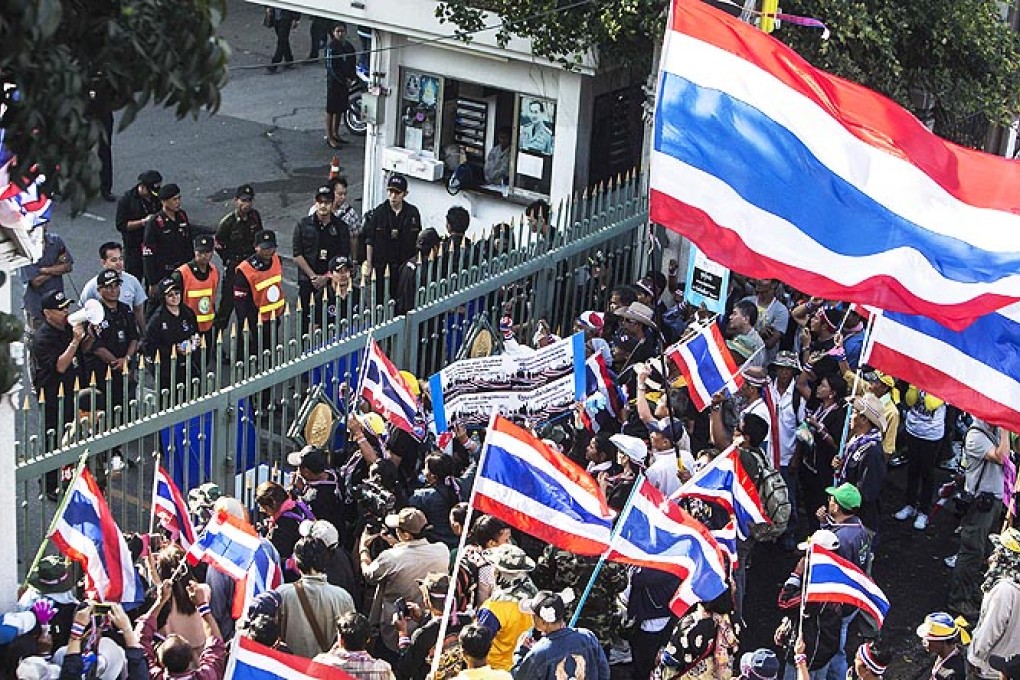 Protesters stand at the gate of the Custom Department office in Bangkok on Tuesday. Photo: Reuters