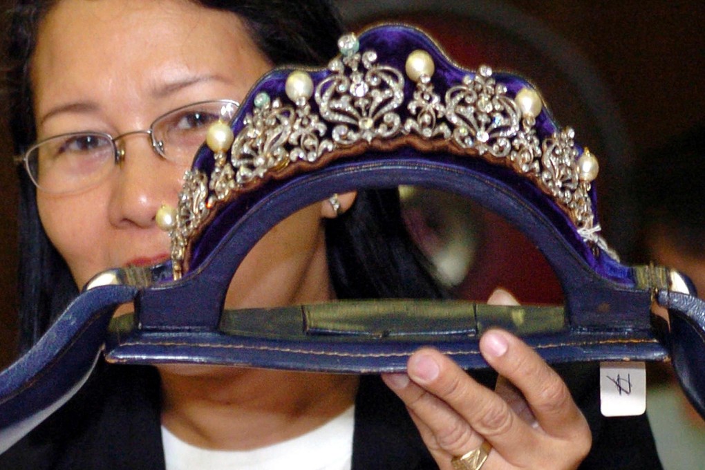 A government official holds a tiara inlaid with diamonds and South Sea pearls from one of the Imelda Marcos collections. Photo: AFP