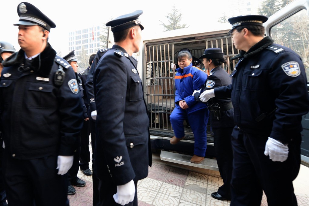 Zhang Shuxia is led into the Weinan Intermediate People's Court in Shaanxi yesterday to face sentencing for selling babies. Photo: Xinhua
