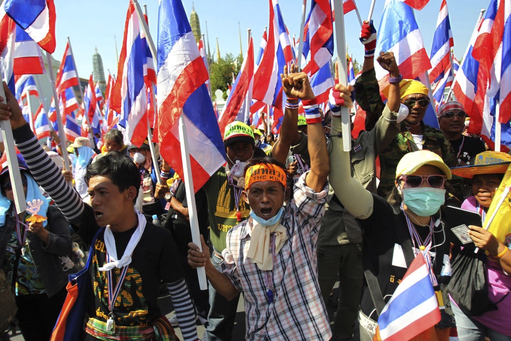 Anti-government protesters hold national flags and shout slogans during a rally in front of Grand Palace in Bangkok, Thailand, Wednesday, Jan. 15, 2014. Photo: AP