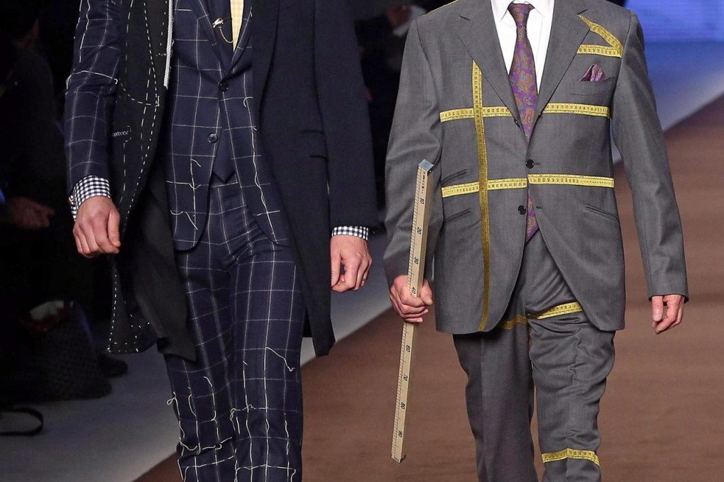 A model and a tailor from Etro on the catwalk.Photo: EPA