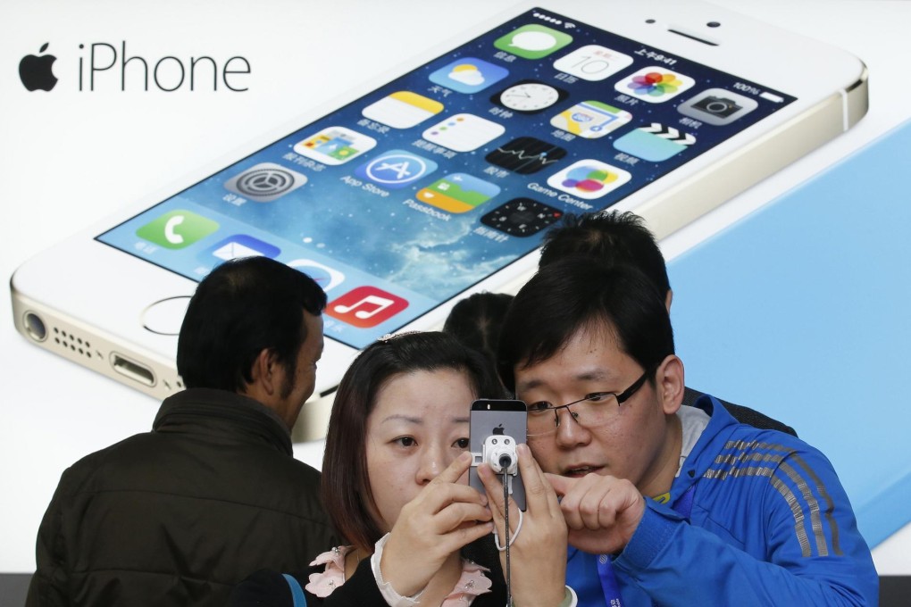 Customers view iPhones at a China Mobile shop. Photo: Reuters