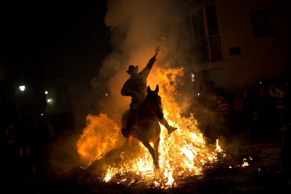 A man rides a horse through a bonfire as part of a ritual in honour of Saint Anthony in San Bartolome de Pinares. Photo: AP
