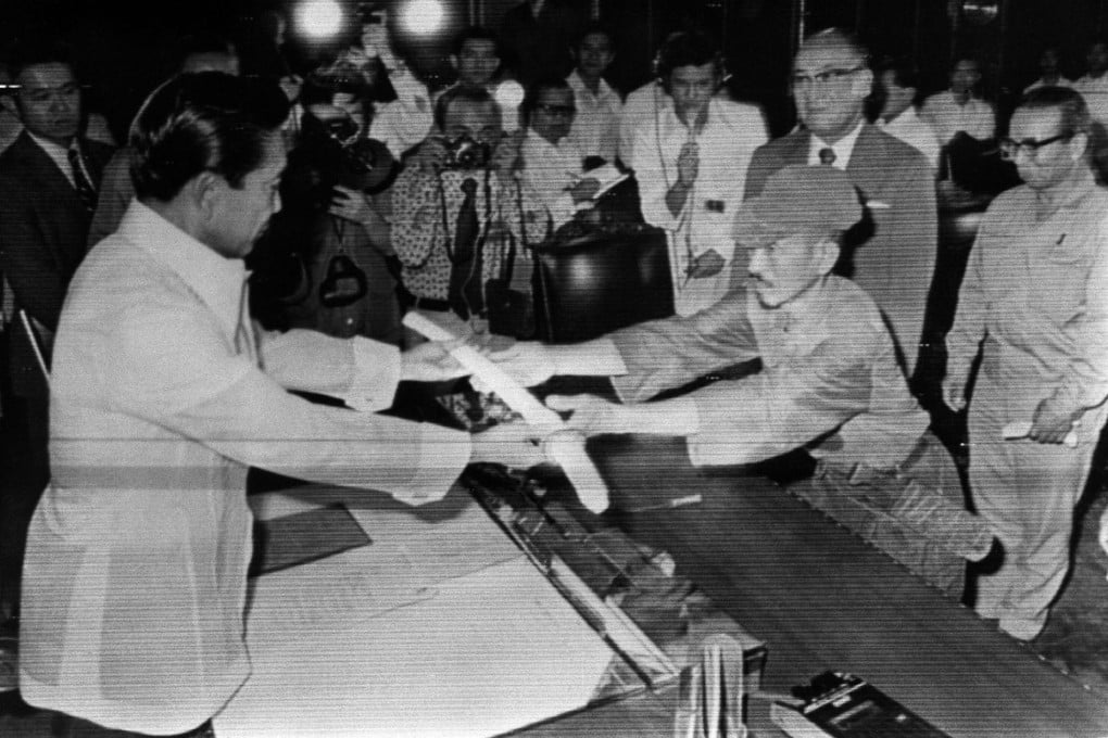 Hiroo Onoda offers his sword to former president Ferdinand Marcos at the Malacanan Palace on March 11, 1974. Photo: AFP