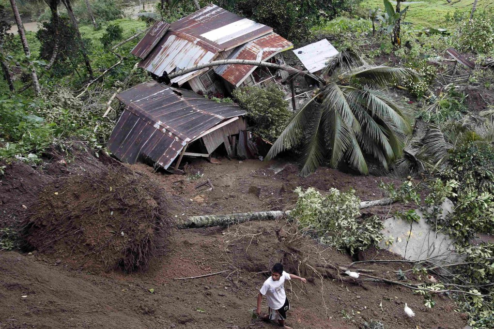 A man walks near houses swept away by landslides in Sibagat, Agusan del Sur in the southern Philippine island of Mindanao. Photo: Reuters