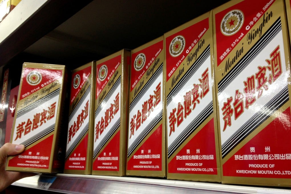 A man takes a bottle of Kweichow Moutai Liquor at a supermarket in Beijing. Photo: Xinhua