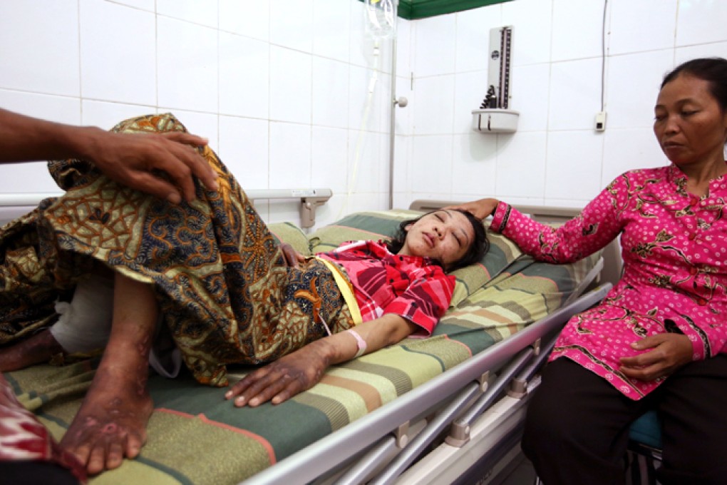 Indonesian domestic helper Erwiana Sulistyaningsih lies in a bed at a hospital in Sragen, Indonesia's Central Java. Right side is her mother Suratmi. Photo: Sam Tsang