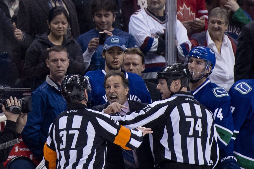 Referees try to calm down Vancouver Canucks coach John Tortorella in their  ill-tempered game against the Calgary Flames. Photo: AP
