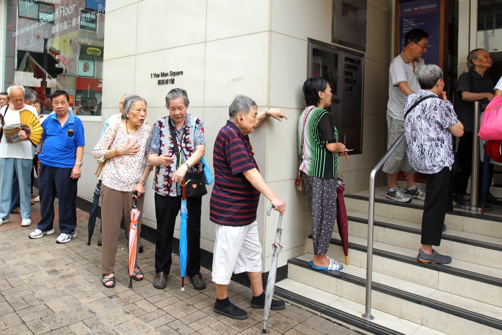 Citizens wait outside a bank for the subscription of the third issue of iBonds - which are issued by the government. The government could issue its first Islamic bond later this year. Photo: Dickson Lee