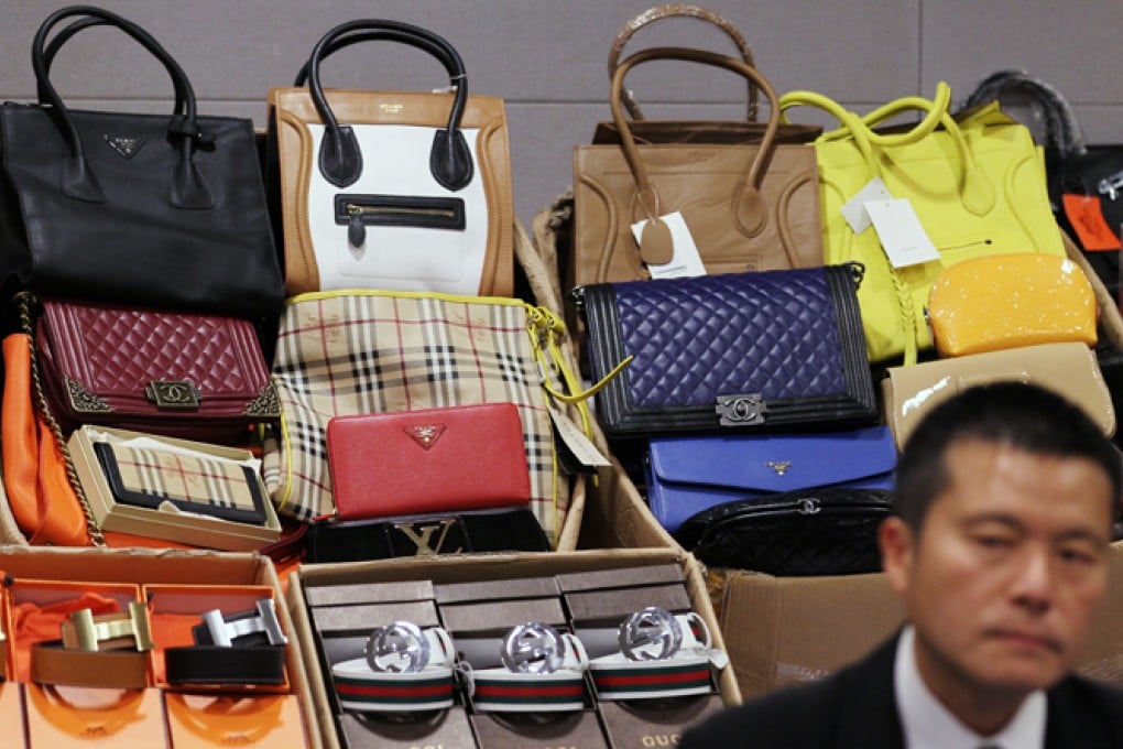 Lui Tze-cheuk, divisional commander of the Intellectual Property Intelligence and Boundary, Investigation Division of Hong Kong Customs, with seized counterfeit goods worth around HK$1.4 million. Photo: Nora Tam