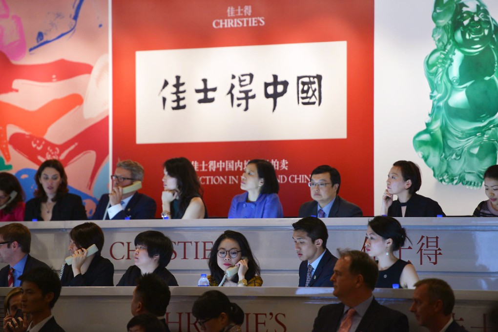 Christie's staff take phone bids at its Shanghai auction in September last year. The firm now has a Chinese-language website. Photo: AFP