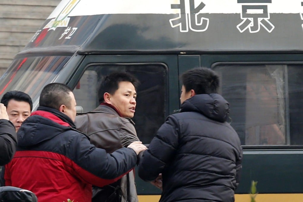 Zhang Xuezhong (centre), a lawyer for dissident Zhao Changqing, argues with police. Photo: Reuters