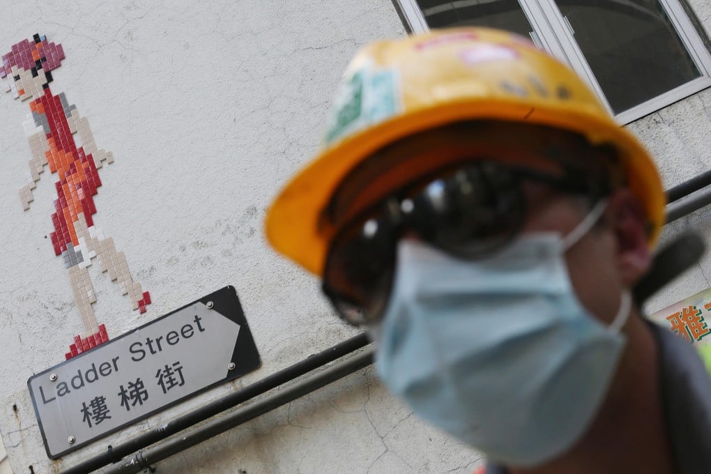 French street artist Invader with an example of his work in Sheung Wan. Photo: SMP