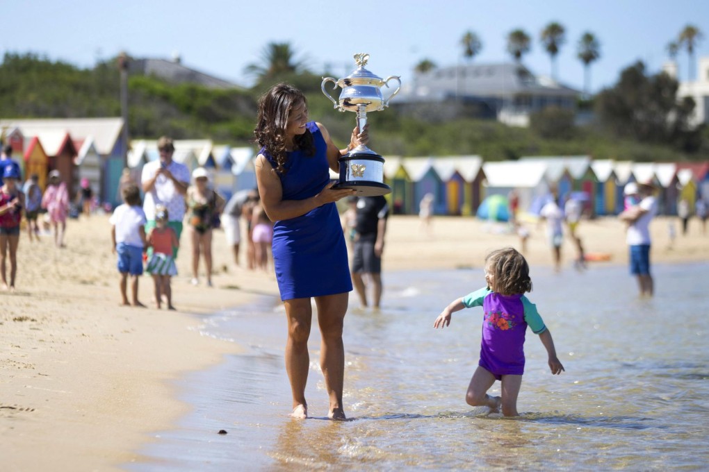 Li Na with a girl at Brighton Beach in Melbourne during a photo call showing the Daphne Akhurst Memorial Cup she won. Photo: Reuters