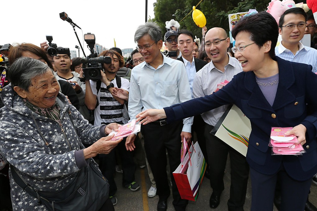 Carrie Lam (right) meets the public - and the trailing media - at a Lunar New Year Fair in Mong Kok yesterday. Photo: David Wong