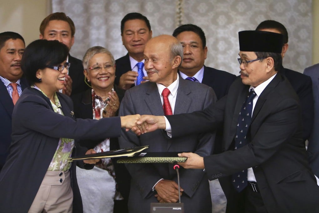 Government of the Philippines chief negotiator Miriam Coronel Ferer shake hands with MILF chief negotiator Mohagher Iqbal at the GPH-MILF Formal Exploratory Talk in Kuala Lumpur. Photo: Reuters