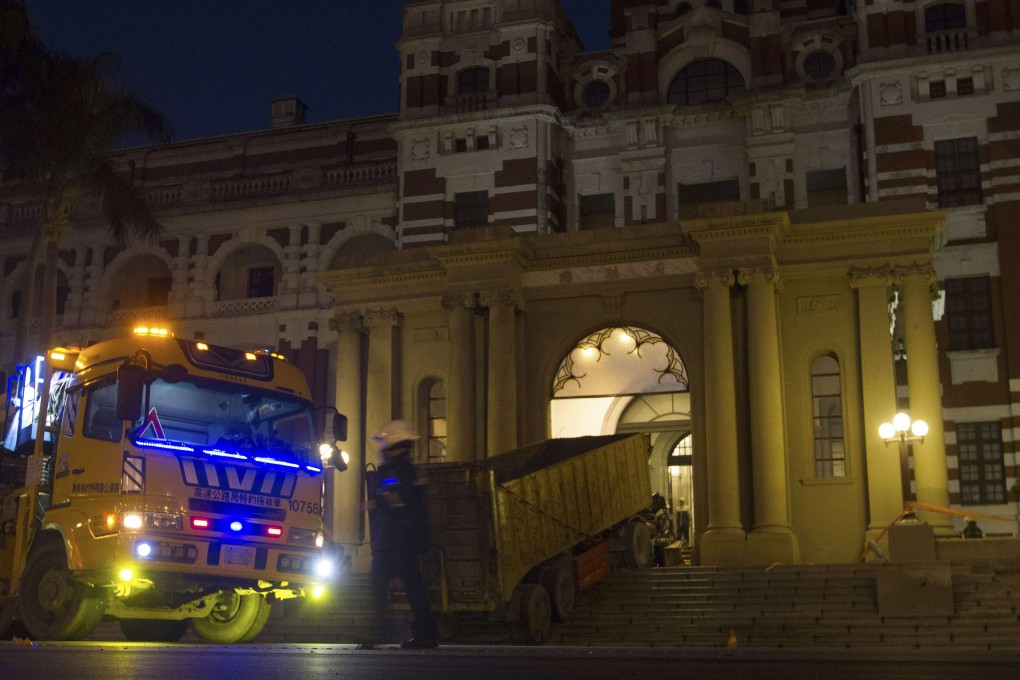 A police officer stands next to a truck which ran into the main gate of President Ma Ying-jeou's presidential office in Taipei. Photo: Reuters