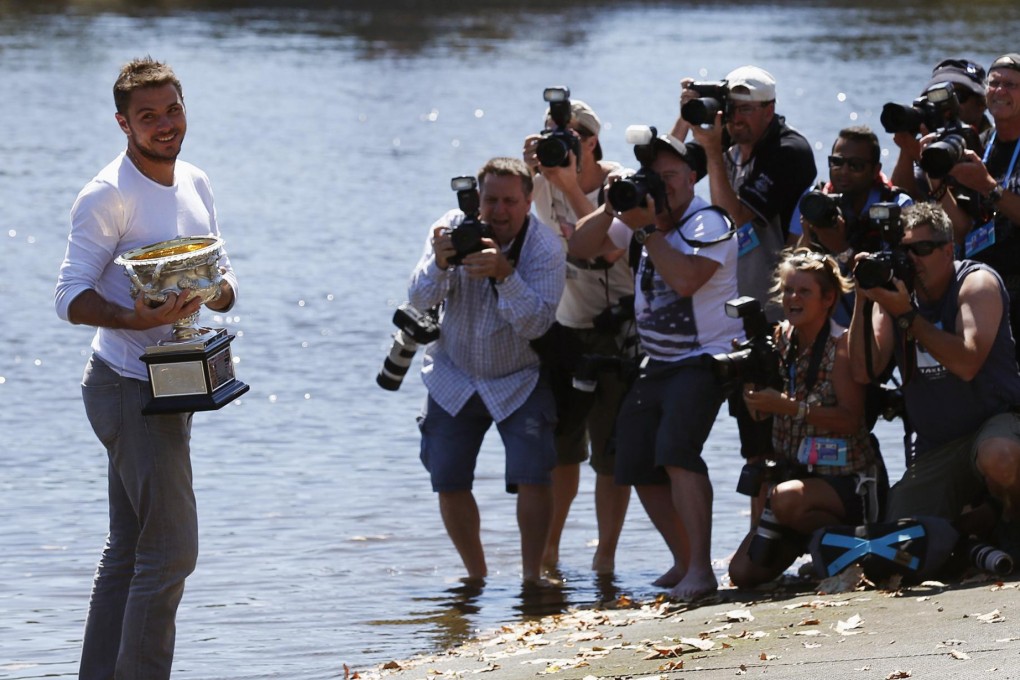 Stanislas Wawrinka poses with the Norman Brookes Challenge Cup on the banks of the Yarra River in Melbourne. Photo: Reuters