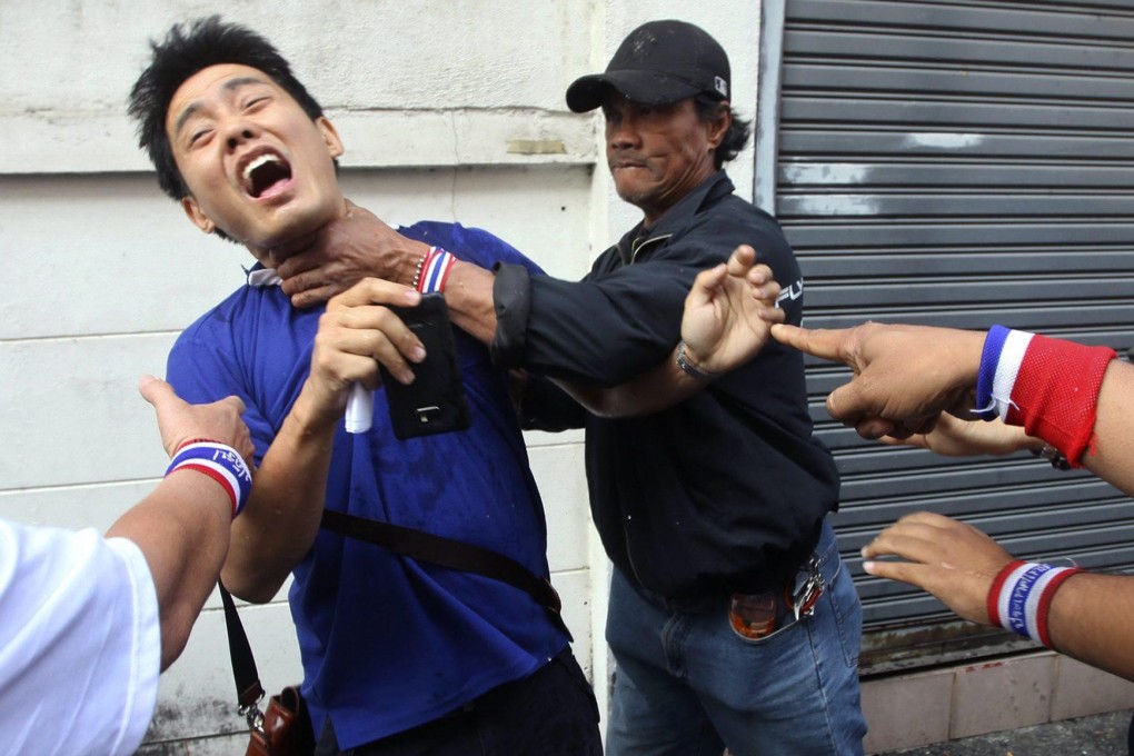 A voter is throttled as he tries to enter a polling station. Photo: EPA
