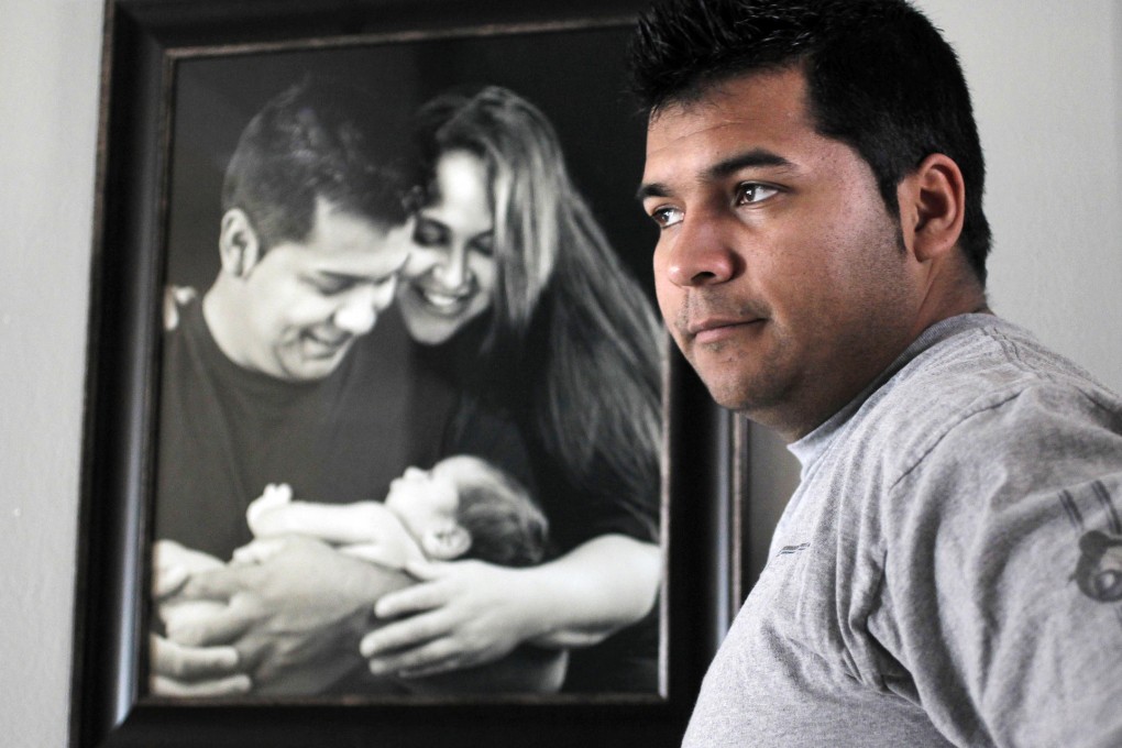 Erick Munoz with a family photo, including son Mateo. Photo: AP