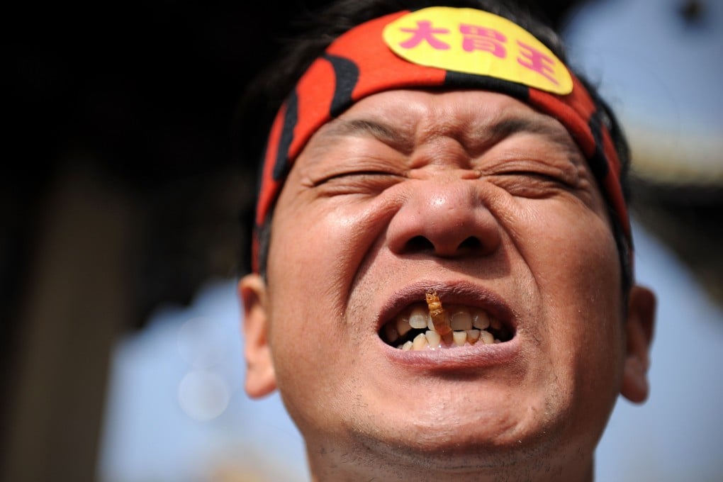 Competitive eater Pan Yizhong chows on a worm during an eating contest in Liuyang, Hunan province. Photo: AFP
