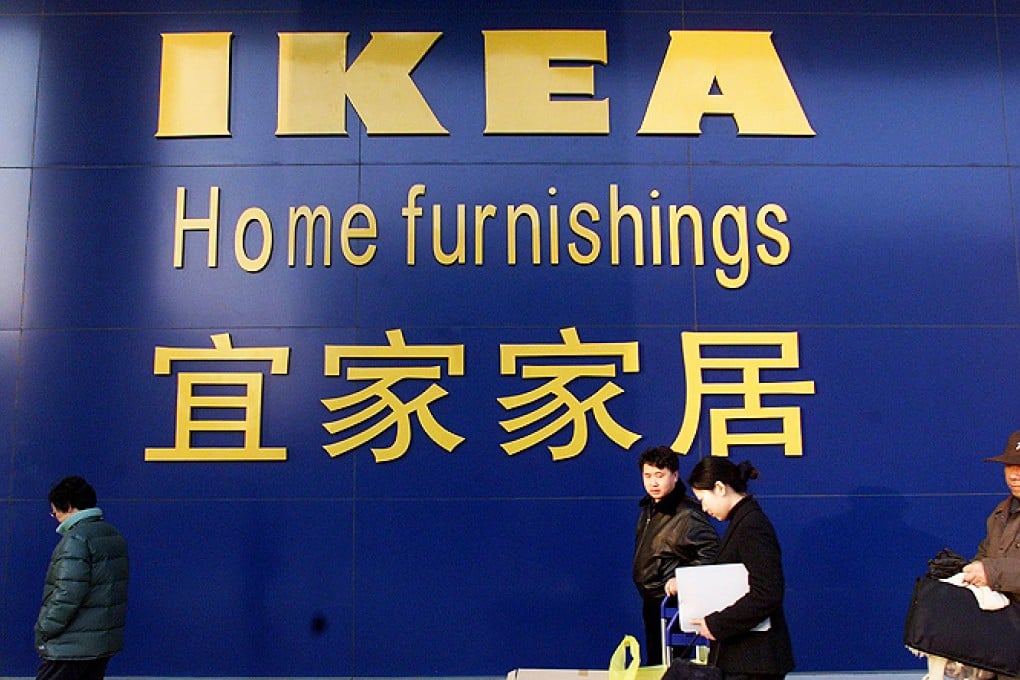 A customer carries her purchases as she leaves IKEA's new Beijing
