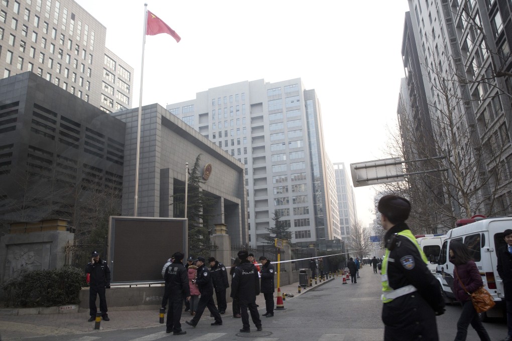 Police stand guard near the Haidian District Court in Beijing as the trial of four New Citizen movement activists begins. Photo: AP