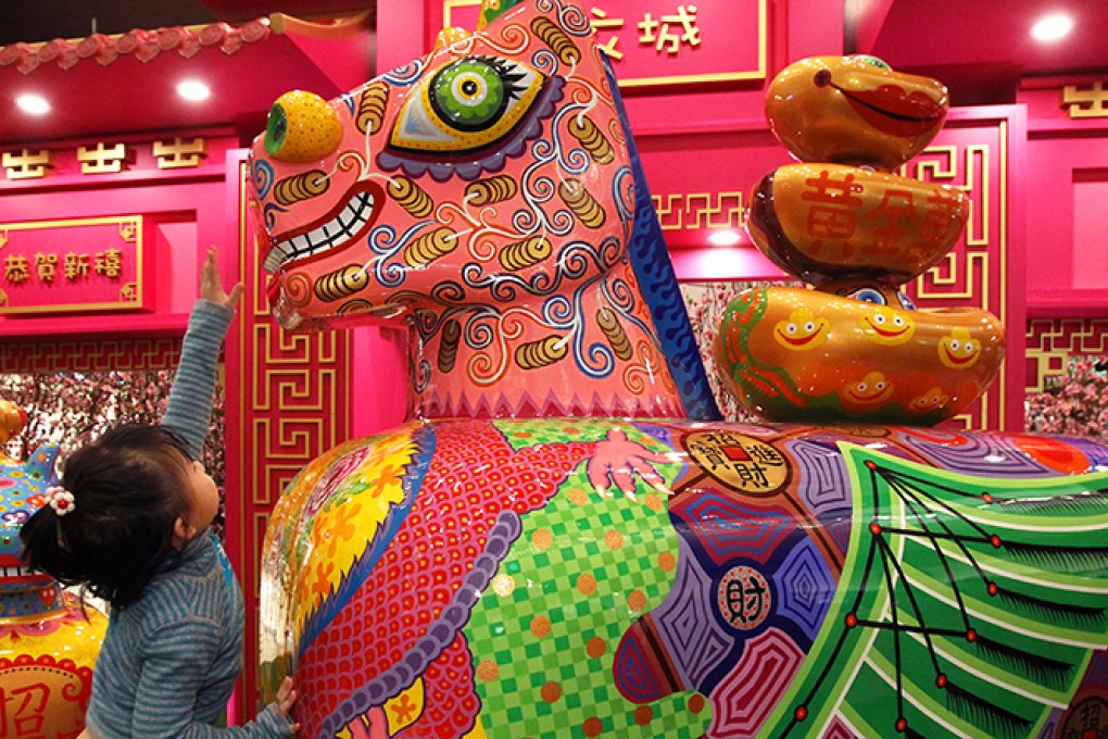 Six-year-old Janis Law Cheuk-ying tries to touch the nose of a Year of the Horse sculpture in Maritime Square, Tsing Yi. Photo: Dickson Lee