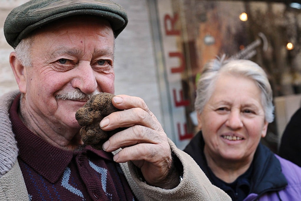 A trader sniffs a truffle in a market in southwest France. Photo: AFP