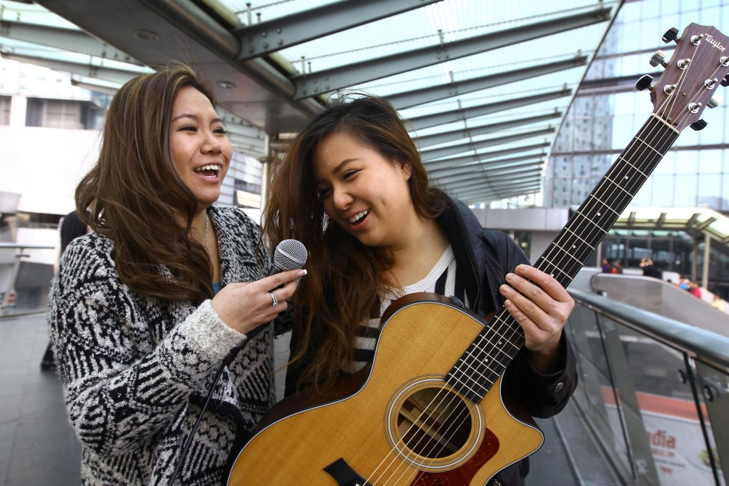 The two Cheung Kit-yings: Kit (left) and Carol with the tools of their busking trade on a Central overpass. Photo: Jonathan Wong