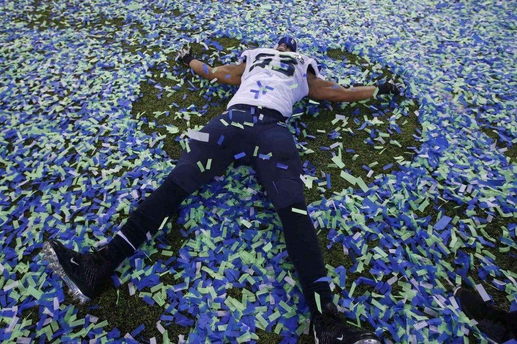 Seattle Seahawks' Malcom Smith cuts an angelic figure in the confetti. Following photos: Seahawks coach Pete Carroll; Doug Baldwin dives for a touchdown; Broncos fans react to a turnover; Russell Wilson showers coach Pete Carroll in Gatorade. Photos: AP, Reuters