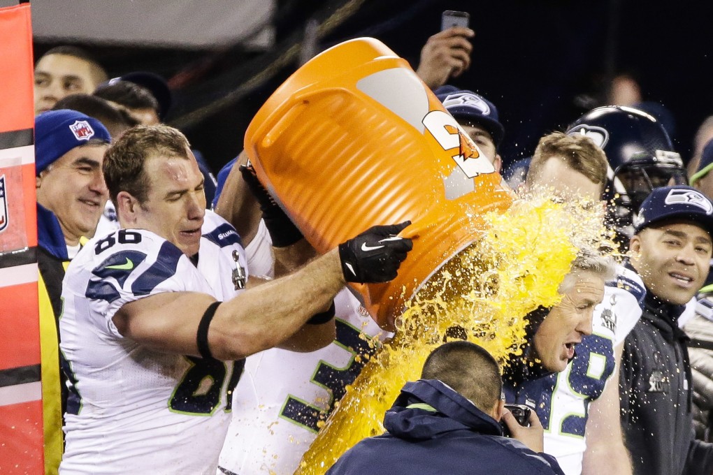 Seattle Seahawks tight end Zach Miller pours a bucket of Gatorade onto head coach Pete Carroll. Photo: EPA