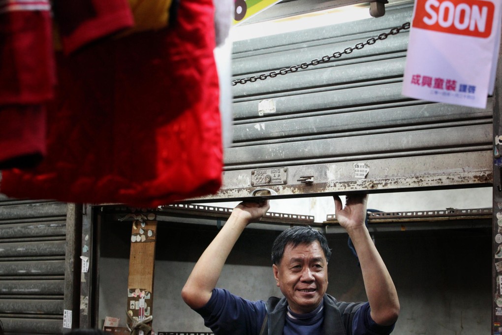 A trader at the Mut Wah Street bazaar pulls down the roller door for the last time yesterday. Photo: Nora Tam