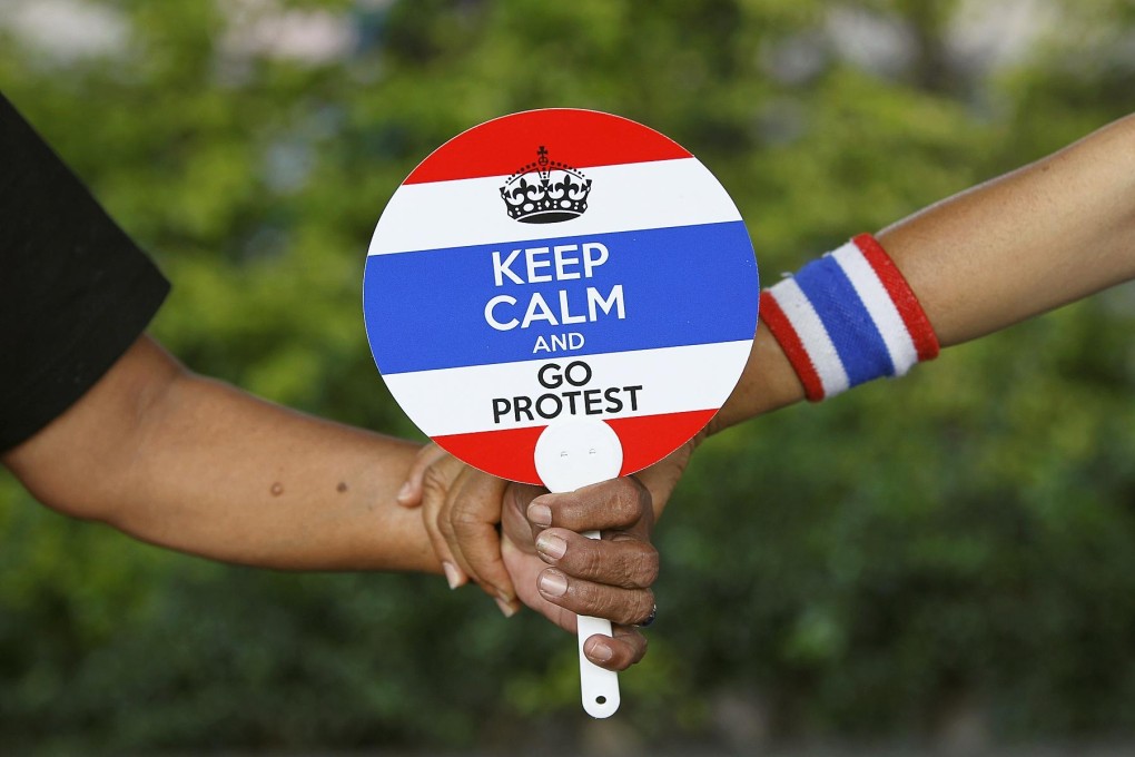 Protesters hold a fan with a variation on the "Keep Calm" slogan. Photo: Reuters
