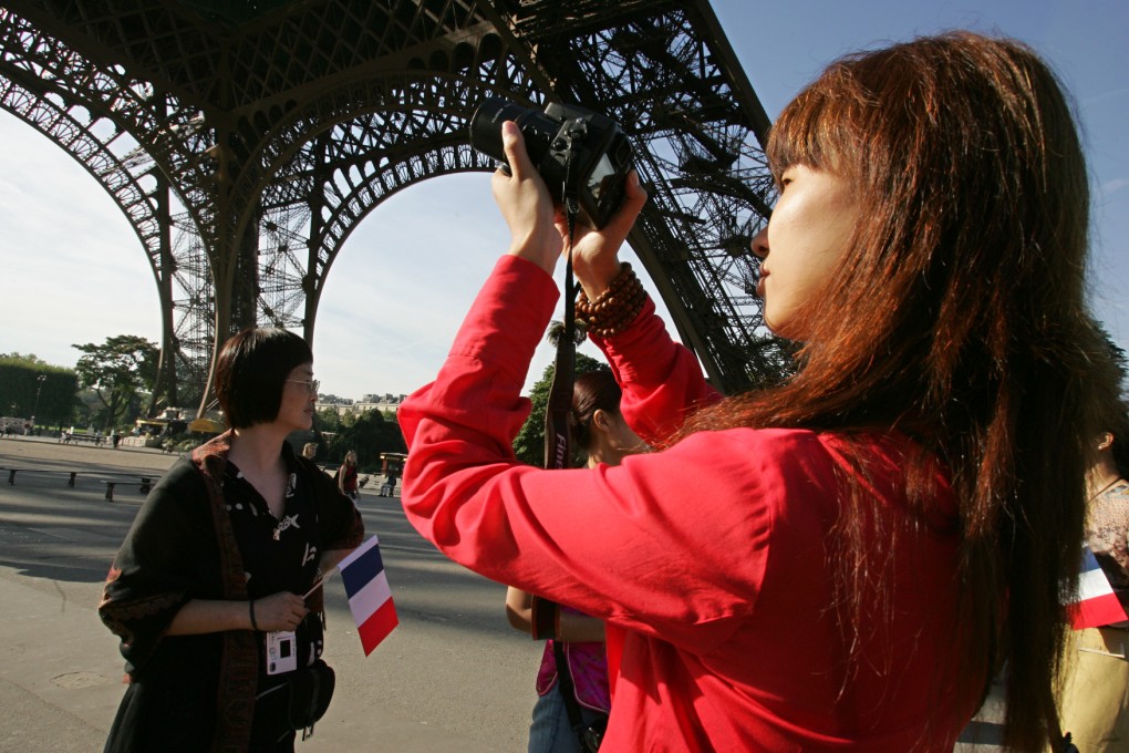A Chinese tourist takes a photo of the Eiffel Tower in Paris, France. Photo: AFP